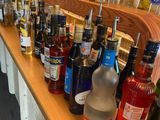 many bottles of alcohol lined up on the bar