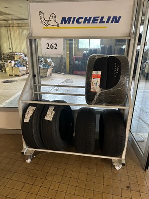 des pneus sont empilés sur un chariot devant la vitrine d'un magasin