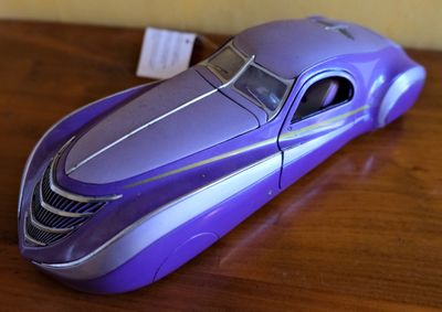 une petite voiture violette posée sur une table en bois