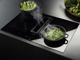 une plaque de cuisson noire sur laquelle se trouve une casserole contenant de la nourriture