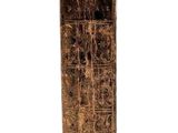 a tall wooden vase with a carved design on it