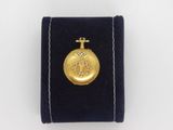a close up of a gold plated pocket watch on a velvet case