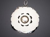 a close up of a necklace with a pearl in the center