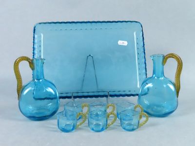 a blue glass table set with blue vases and glasses