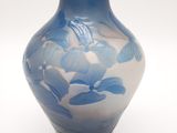 un vase bleu et blanc posé sur une surface blanche