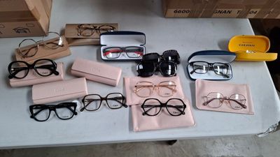 Plusieurs paires de lunettes sont posées sur une table à côté d'une paire de lunettes