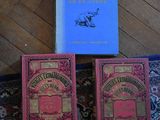 two books are sitting on a rug next to a blue book