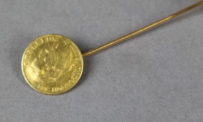 a close up of a gold coin on a stick on a table