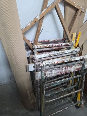 une pile de pinceaux posée sur une chaise en bois