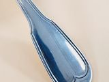 a silver spoon with a blue handle sitting on a table