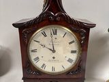 a wooden clock with roman numerals on the face