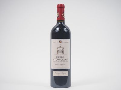 une bouteille de vin rouge posée sur une table blanche