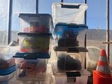 many plastic containers sitting on a shelf in front of a window