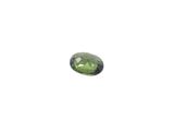 a close up of a green tourmaline stone on a white surface