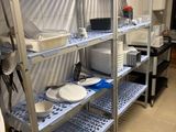 une étagère en métal sur laquelle sont posés des plats, dans une cuisine