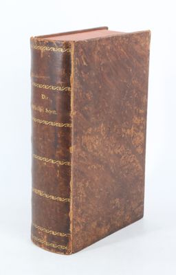 un vieux livre à la couverture brune posé sur une surface blanche