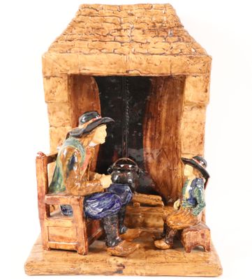 a figurine of a man and a woman sitting in front of a fireplace