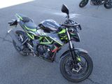 une moto noire et verte garée sur le bord de la route