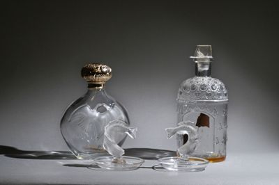 a glass bottle with a horse on it next to a glass bottle with a horse on it