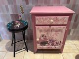 a small table with a drawer on it next to a stool