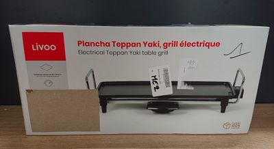 the box is open on a table with a black grill