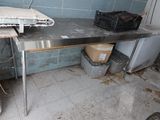 a metal table with a metal top in a dirty room