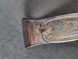 a silver spoon with a metal handle on a table