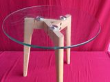 une table en verre avec des pieds en bois et un plateau en verre