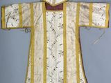 une photo d'une robe blanche et jaune avec un col