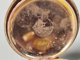 a close up of a pocket watch on a table