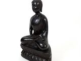 statue of buddha sitting on a rock on a white background