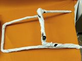an orange chair with a white rope on top of it