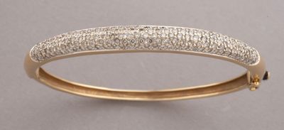 a close up of a gold bang with diamonds on it