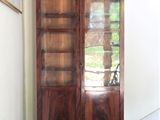 un grand meuble en bois avec des portes en verre dans une pièce