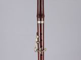 a close up of a wooden clarinet on a clear surface