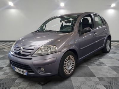 a picture of a small grey car parked in a garage