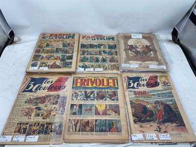 Plusieurs bandes dessinées anciennes sont exposées sur une surface blanche