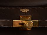 a close up of a black leather bag with a gold buckle