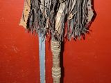 a wooden pole with a bunch of fringes on top of it