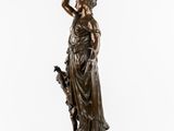 a bronze statue of a woman holding a dog