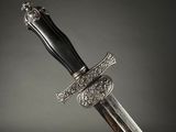 a close up of a sword with a silver handle on a black background