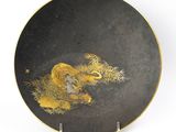 une image représentant une assiette ornée d'un lion, posée sur un socle