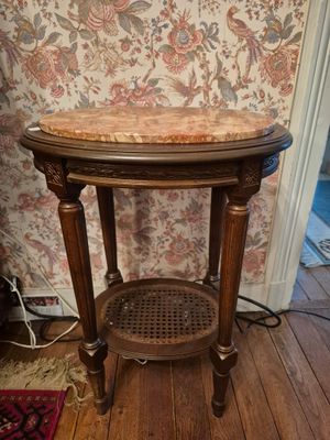 une table en bois avec un plateau en marbre posée sur un parquet en bois massif