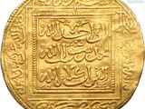 a close up of a gold coin with arabic writing on it