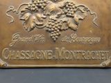brass plaque of a bunch of grapes on a black background
