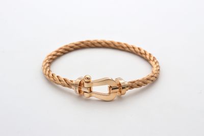 un bracelet en or en forme de corde avec un fermoir, sur fond blanc