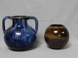deux vases posés l'un à côté de l'autre sur une surface blanche