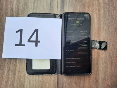 a cell phone with a number 14 on it next to a notepad