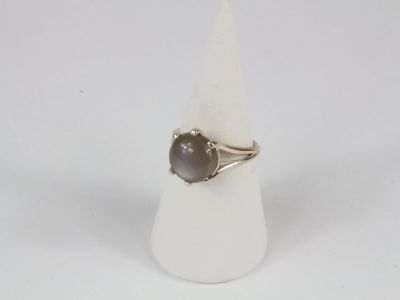 bague en argent ornée d'une pierre brune posée sur un cône blanc