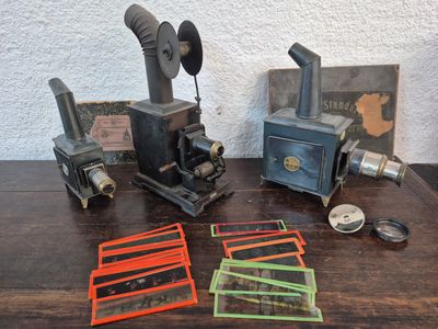 une table sur laquelle sont posés quelques anciens appareils photo et d'autres objets